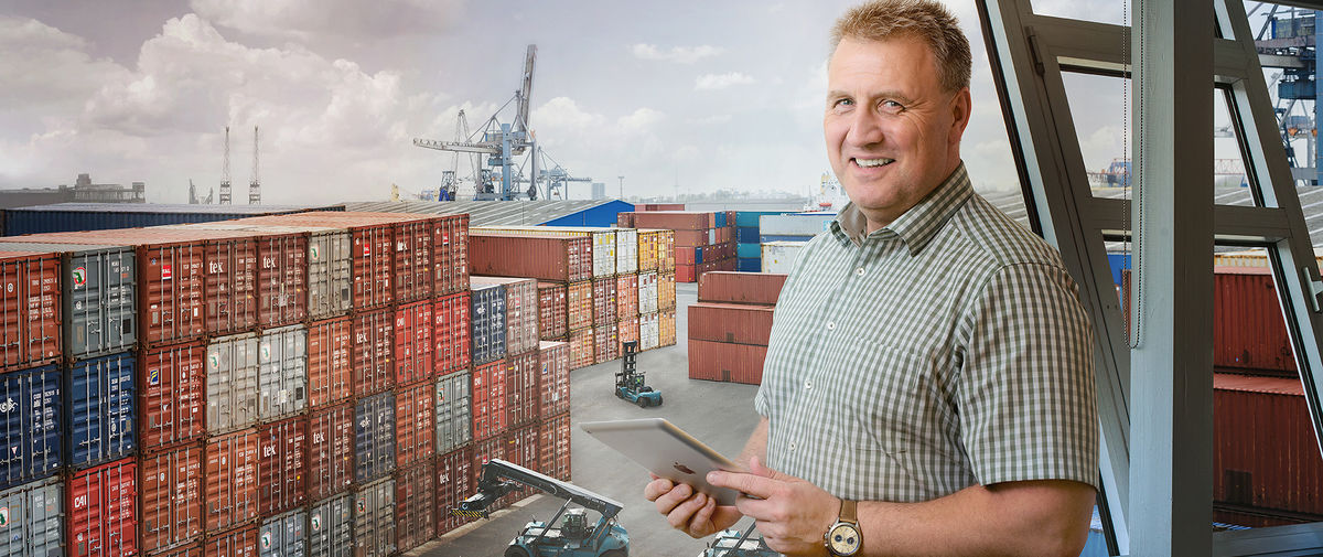 Manager with tablet standing in front of ports
